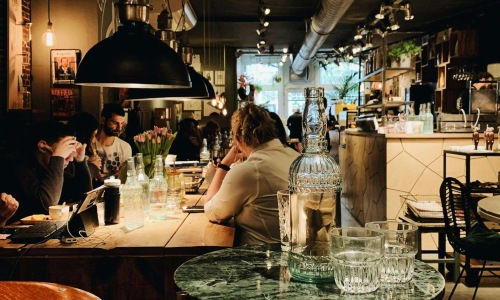 people sitting at tables in a restaurant
