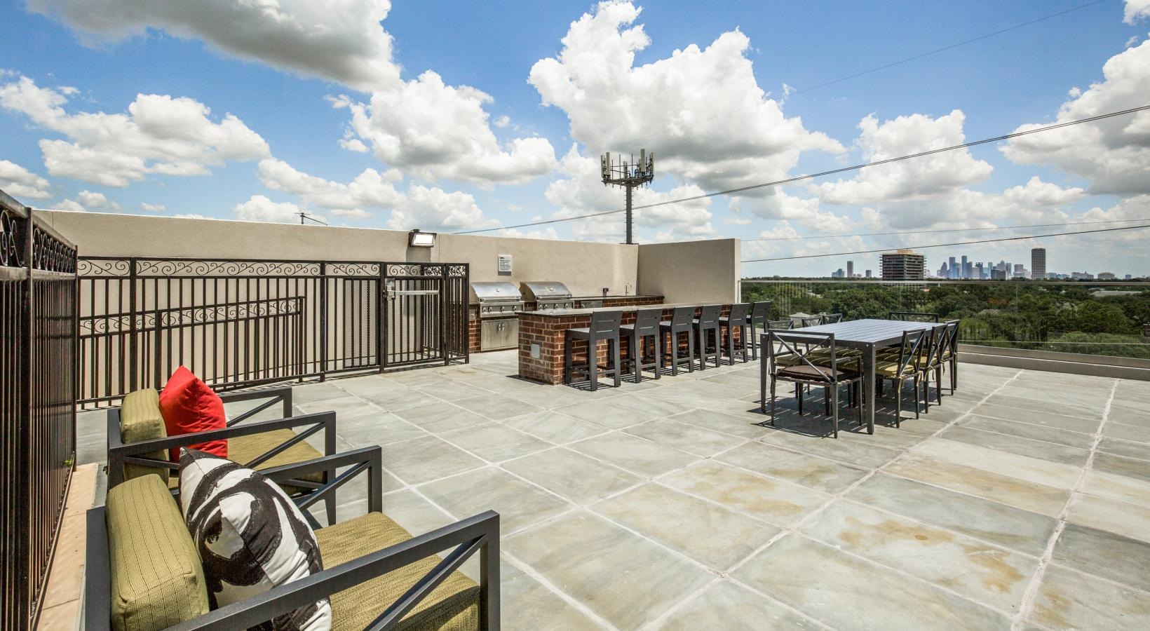 Find your perfect fit at The Ivy a rooftop deck with a grilling area and chairs