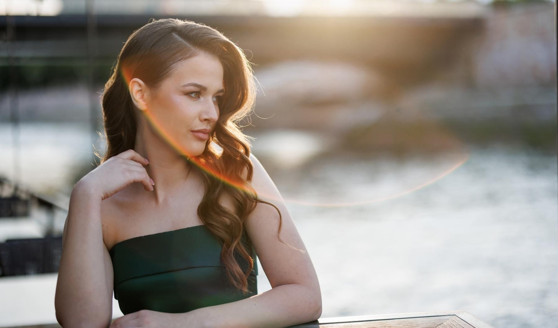 The essence of exceptional living a woman in a green dress near water