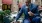 a person in a suit eating a sandwich and near a laptop