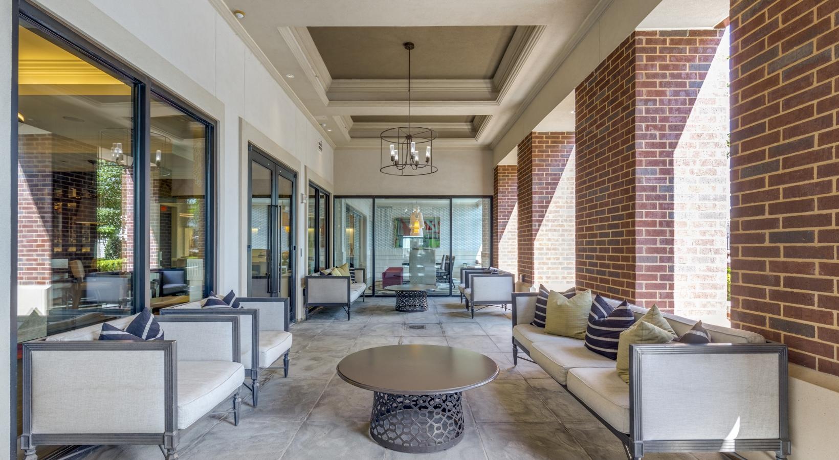 Access to resident-only features an outdoor room and walkway with a brick pillar