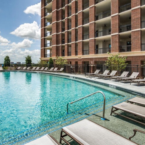 Relax and unwind poolside a swimming pool outside of a building