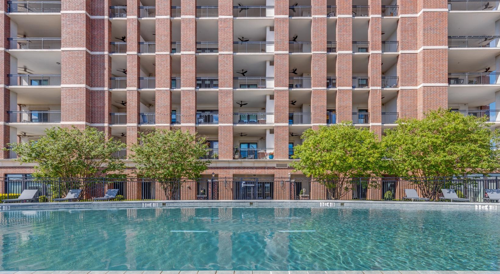 Shimmering resort-style pool a large building with a pool in front of it